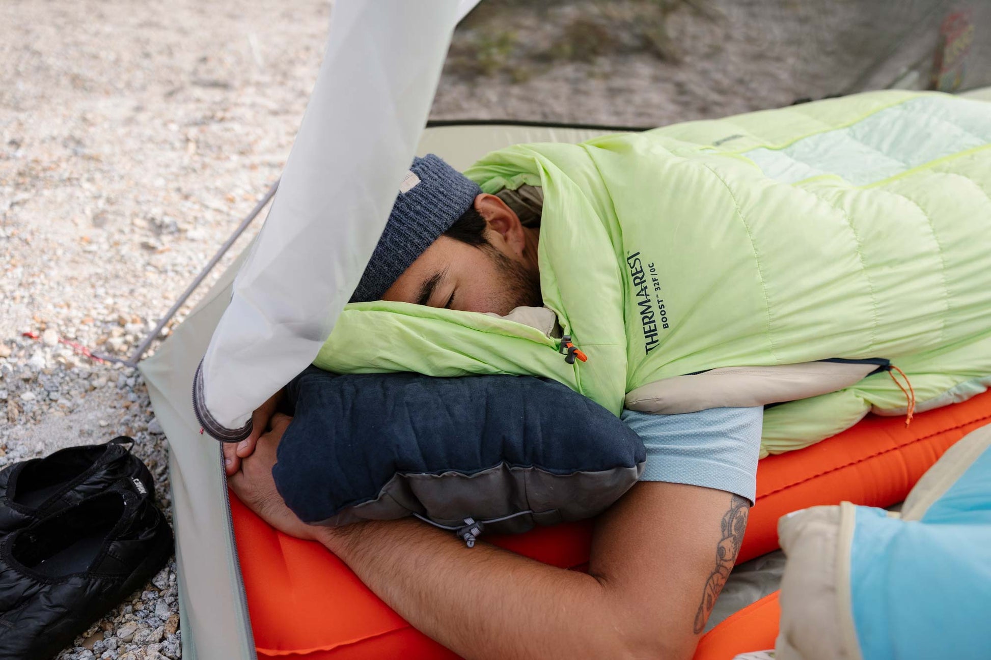 Camper side sleeping on a foam camping pillow inside a tent