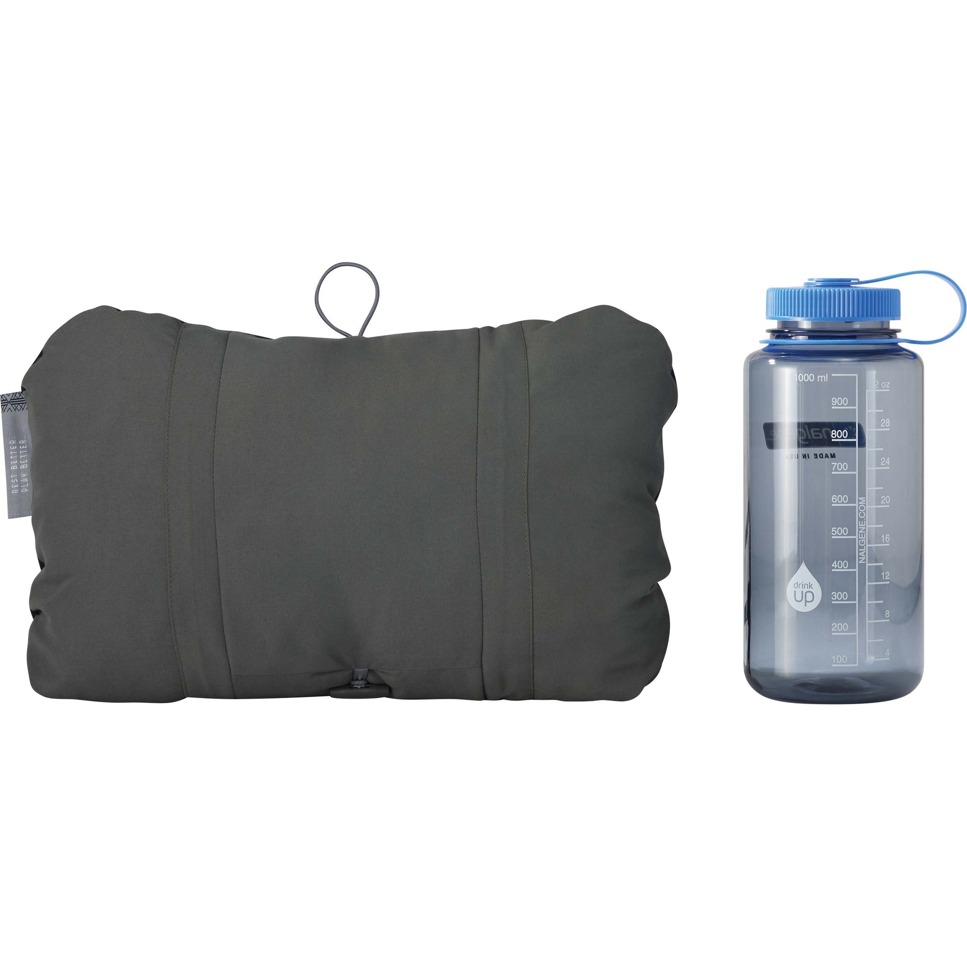 Compressible camping pillow shown beside a one-liter bottle for size comparison