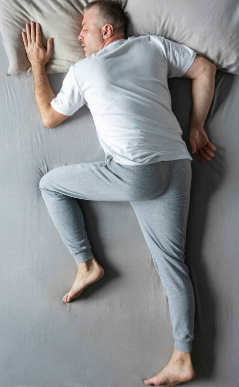 A person sleeping flat on their stomach without a pillow, showcasing spine alignment.
