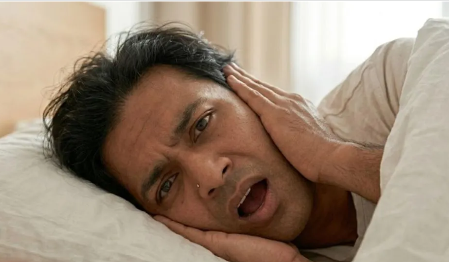 Side sleeper resting on a soft bed showing ear pressure pain