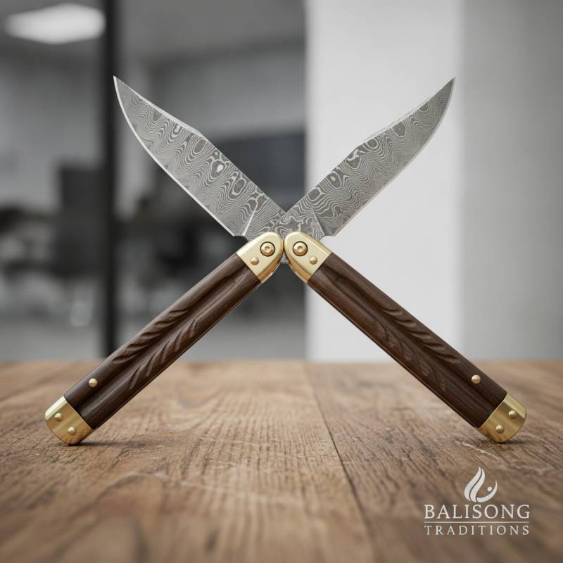 A traditional Filipino balisong butterfly knife resting open on a rustic wooden table, showing its dual-handle design and blade pivot points