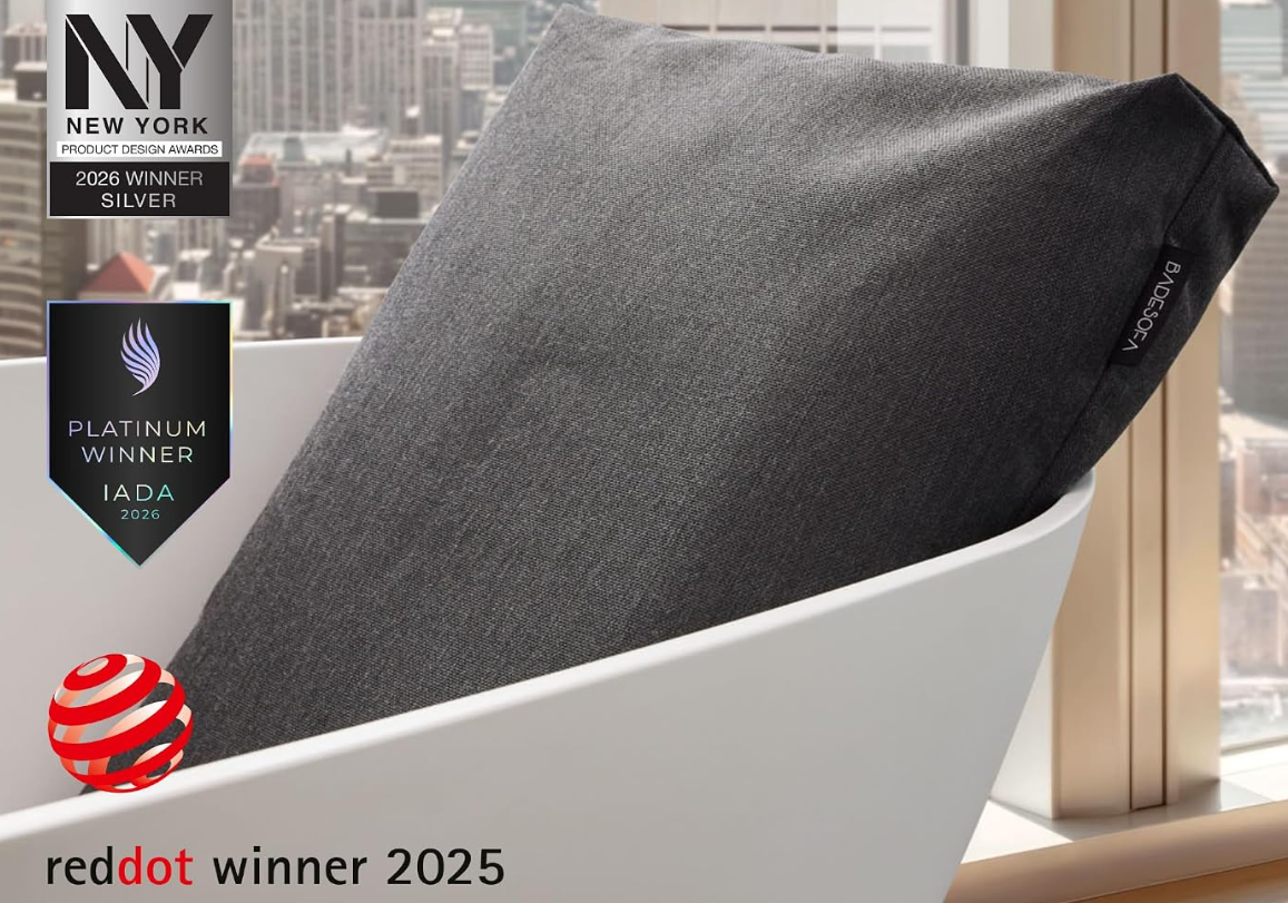 Person relaxing on a BADESOFA bath pillow with neck and back support
