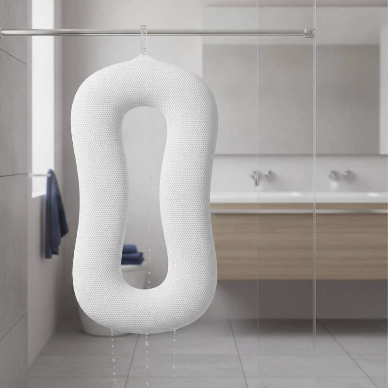 A white full-body bath pillow hanging to dry from a shower rod using its built-in hook.